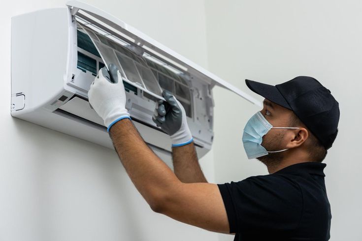 Technician repairing an indoor AC unit